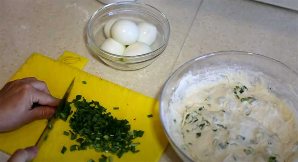 В тесто добавьте начинку – зеленый лук и сокрушенные кубиками яйца.