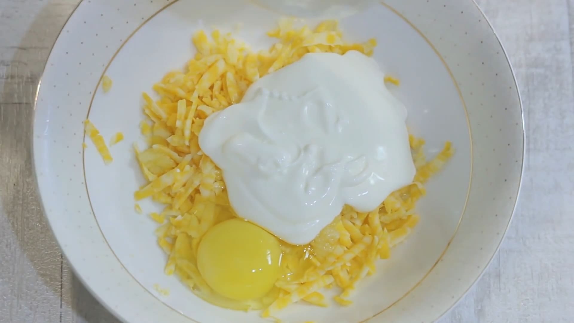 В одну половину сыра добавляем яйцо и чеснок со сметаной.