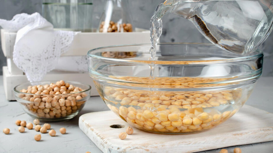 Замачивание нута перед варкой: время и правила Процесс замачивания нута в воде в стеклянной миске перед приготовлением.