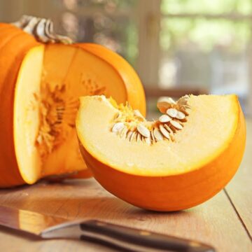 Сколько семечек в одной тыкве Разрезанная спелая тыква с большим количеством свежих белых семечек